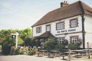 The outside of The White Horse Pub including benches and trees
