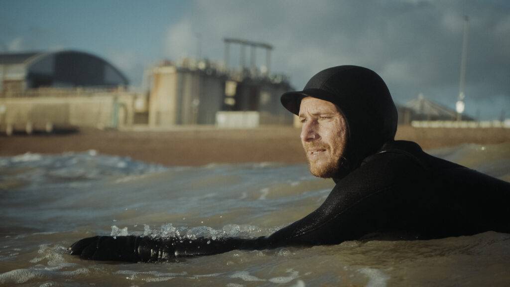 Surfer in water on surf board on front of Shoreham harbour