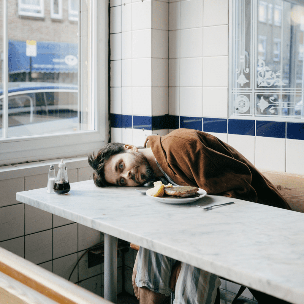 Joz Norris with his eyes wide open and his head on a diner table