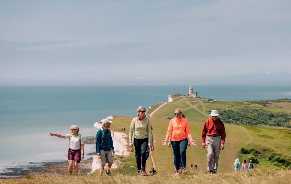 People walking along the Sussex coast on a sunny day